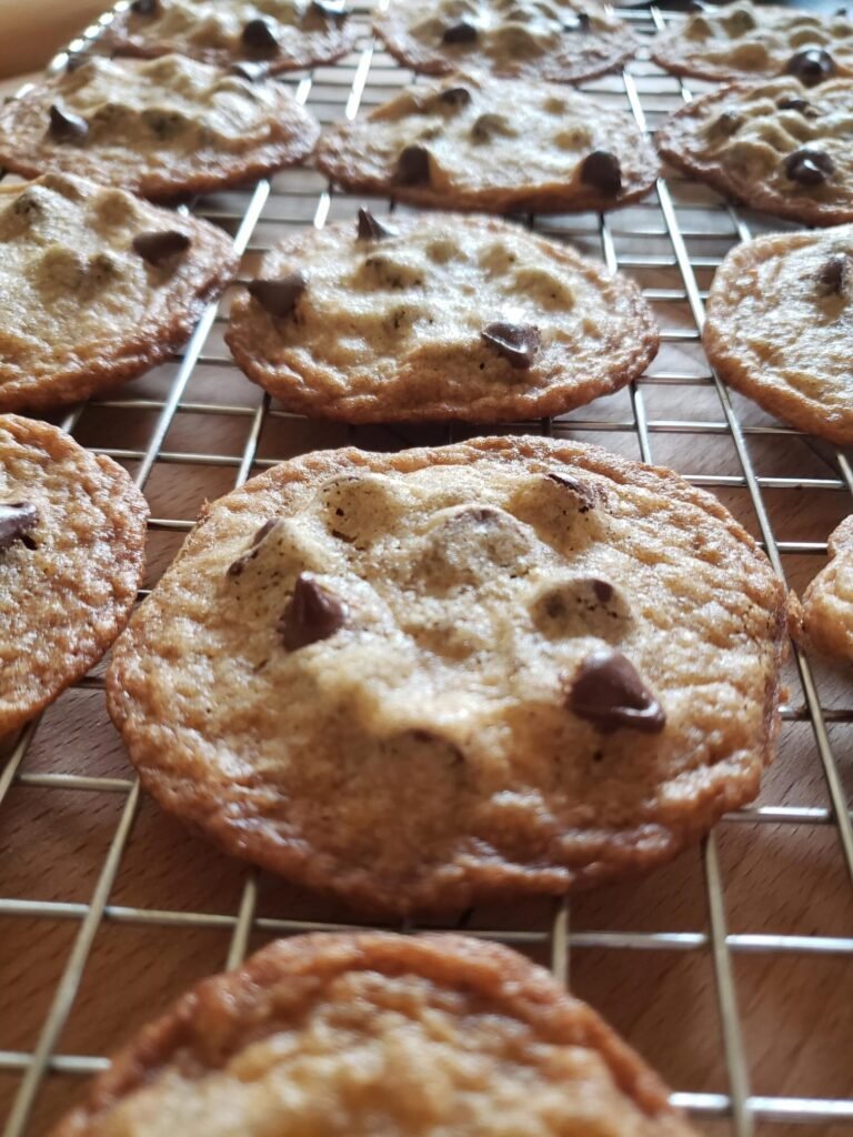 Chocolate chip cookies on a cooling rack.